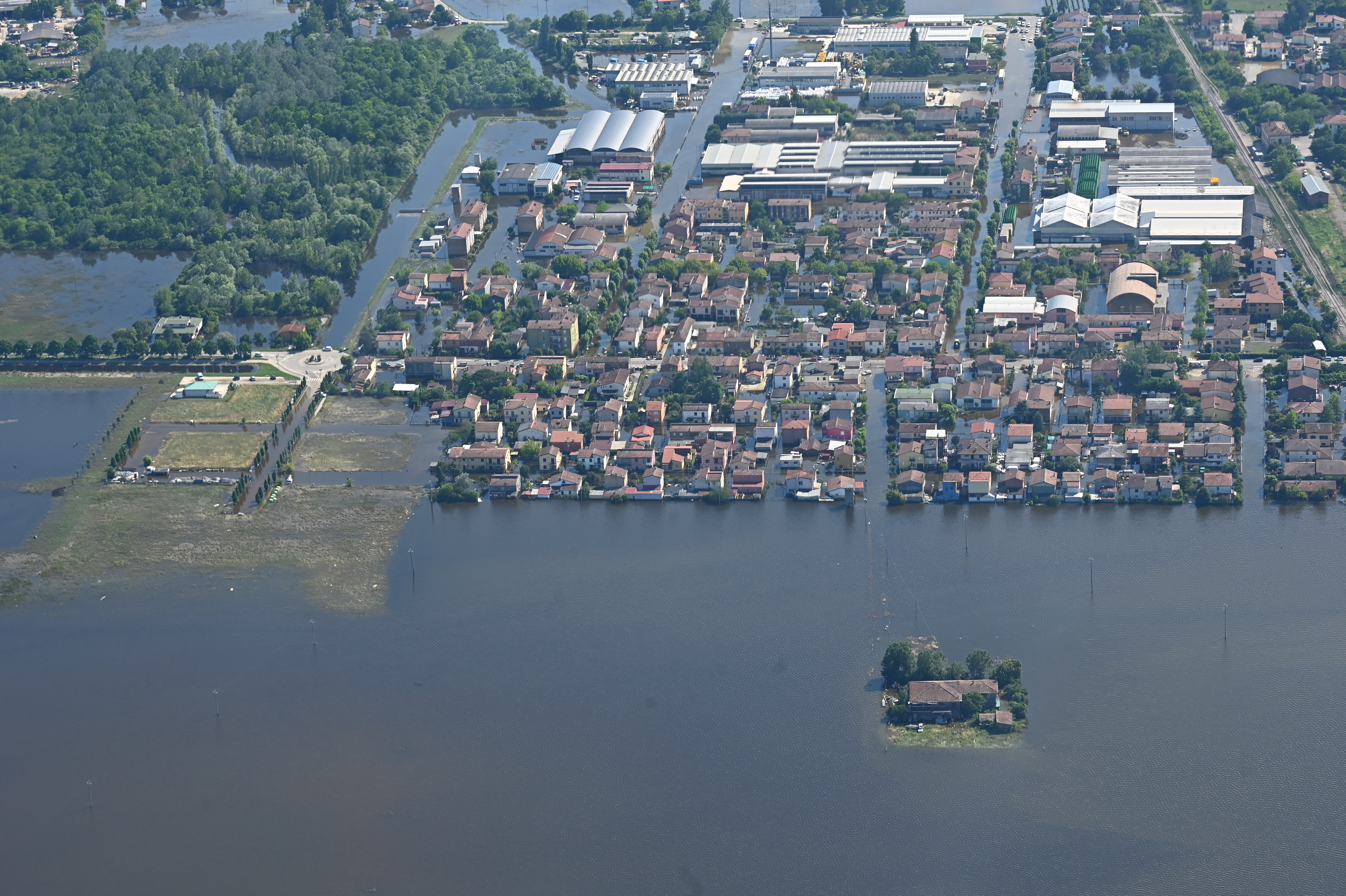 Aerial view of a flooded town in Emilia Romagna, Italy. The flood waters have surrounded the houses, leaving some completely cut off.
