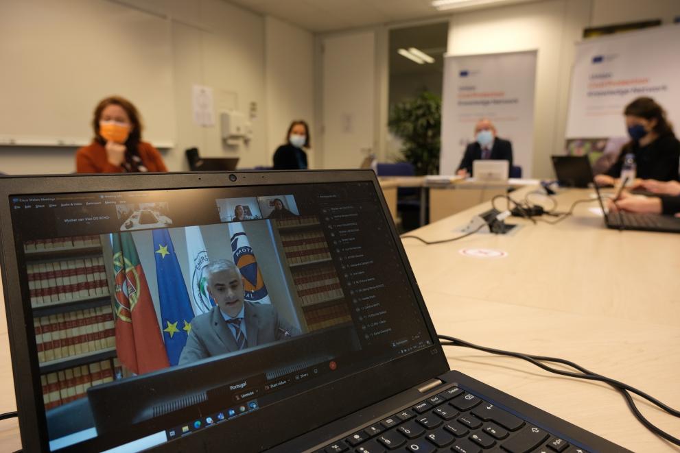 Image shows meeting participants watching the online KN Board meeting on screen during Knowledge Network Day.