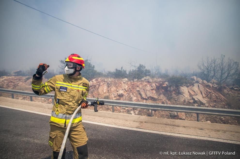 A Polish firefighter deployed to Greece via the EU Civil Protection Mechanism is extinguishing a fire