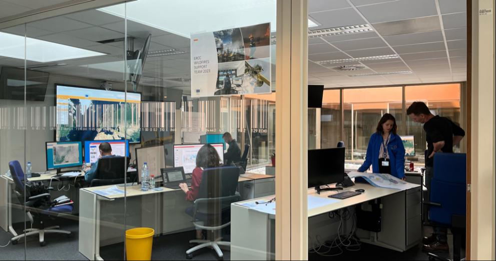 People working in an open plan office with glass walls