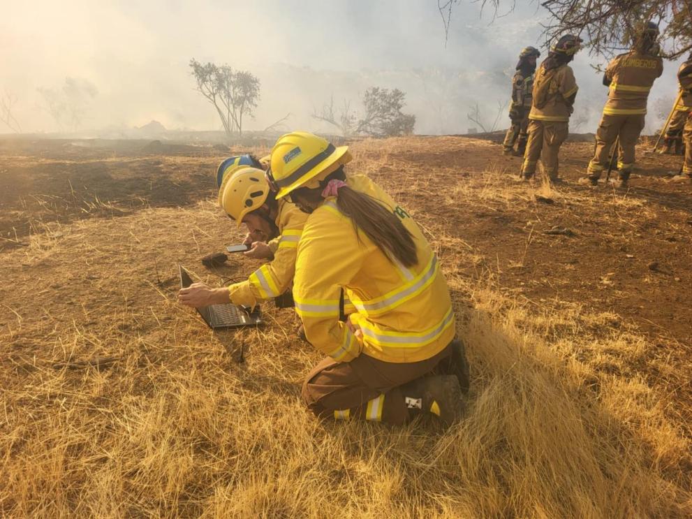 EWED and CONAF (Corporación Nacional Forestal)  members assessing data from a recently launched  radiosonde at the Manuel Rodríguez wildfire, Chile,  February 2025. Photo credit EWED © EU 2025