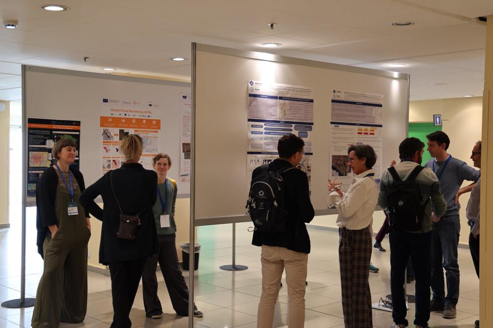Participants to the event gathered in between white boards with posters presenting different projects.