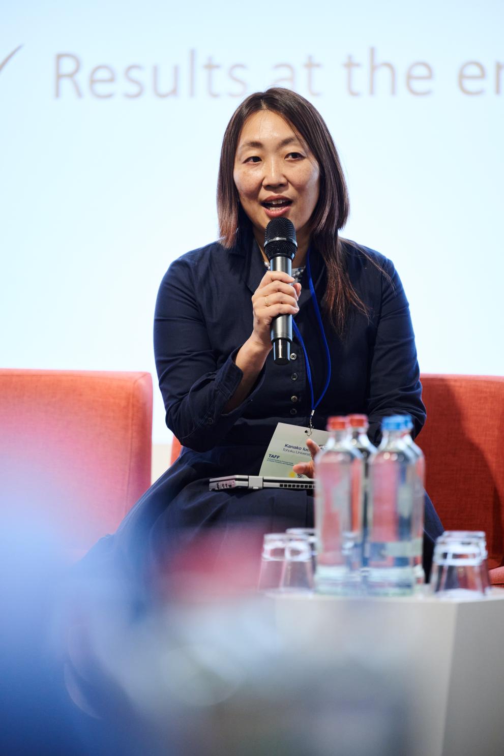 Professor Kanako Iuchi, seated, with a microphone, during a panel.