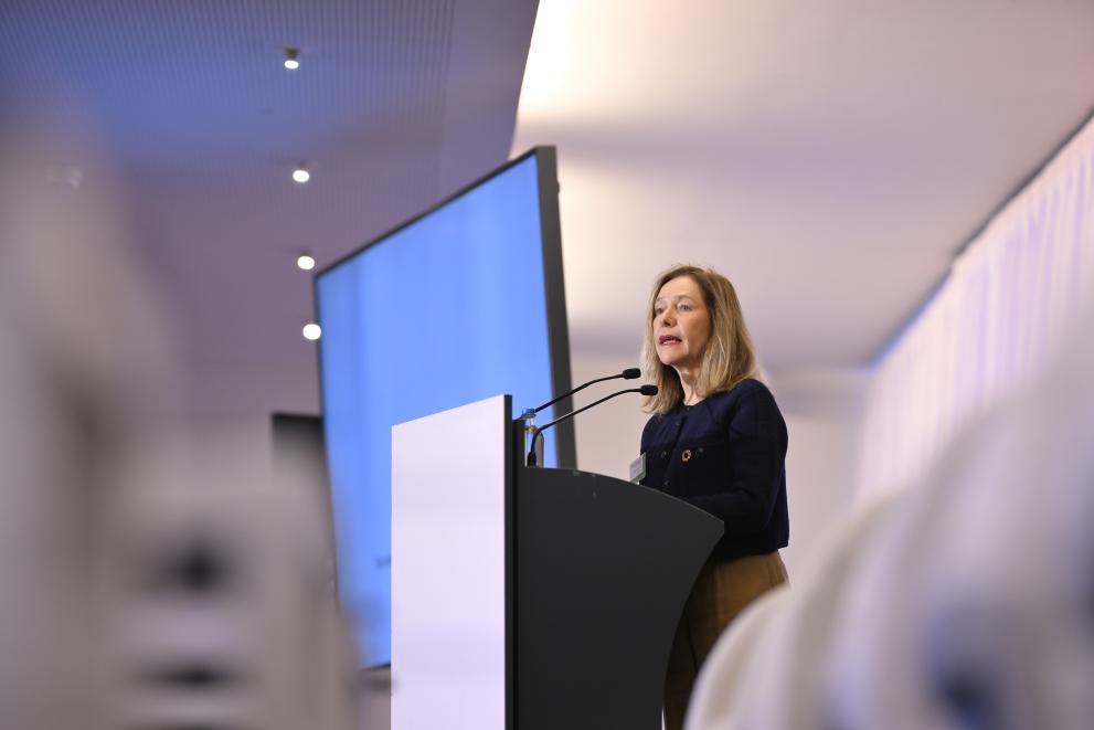 Celeste Saulo stands at a lectern on stage, speaking in two microphones, delivering her speech. 