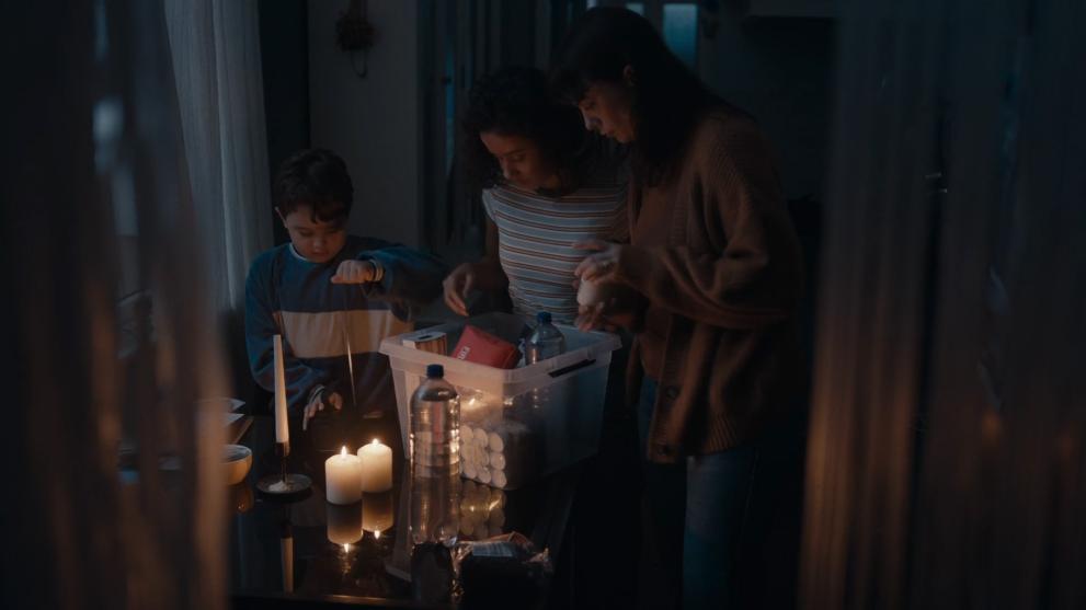a family gathered together in a candle lit room with an emergency kit