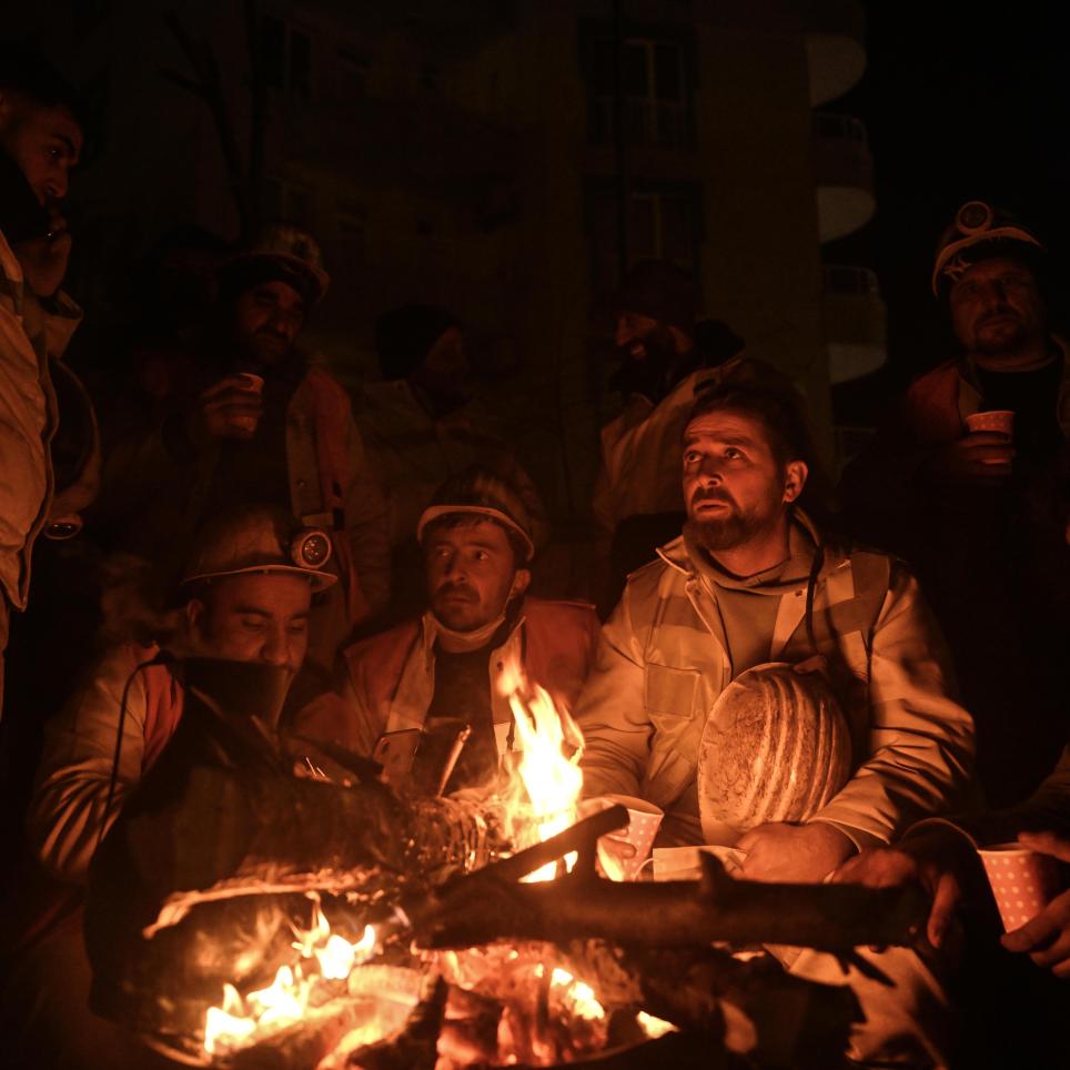 Miners gathered around a fire after a hard day 