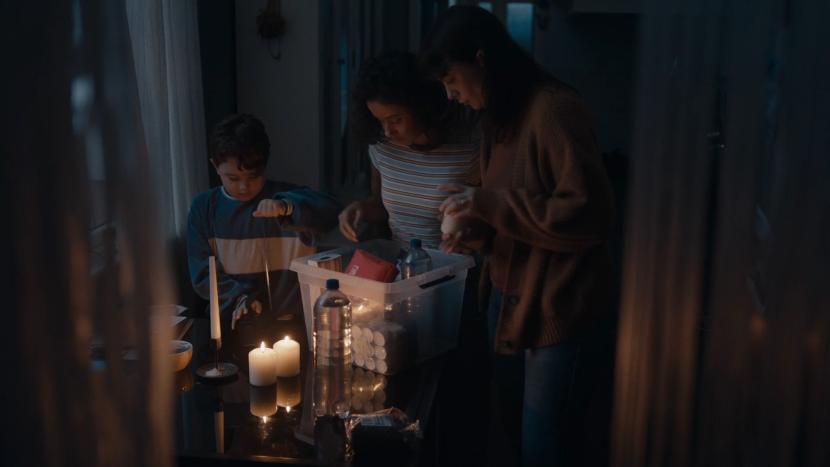 a family gathered together in a candle lit room with an emergency kit