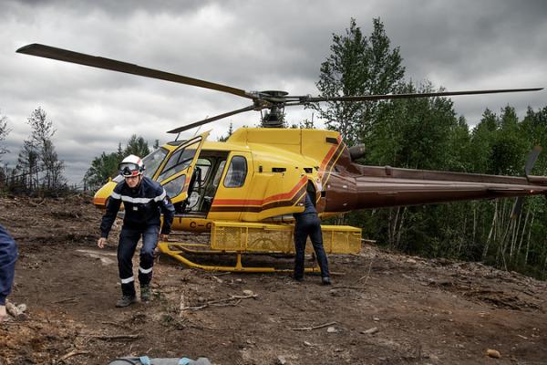 Captain Jerome Jallet from France walks away from a helicopter after an aerial survey of the woodlands his team is working in.