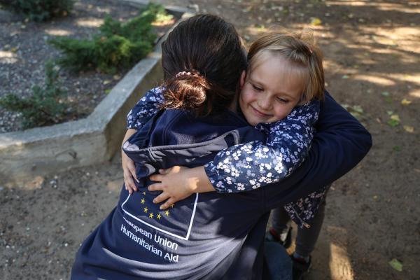 A volunteer hugging a child 