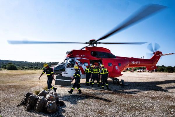 A helicopter and two firefighters during a FXS-Domino exercise.