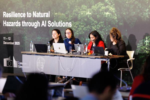 Four women seated on stage during the meeting.