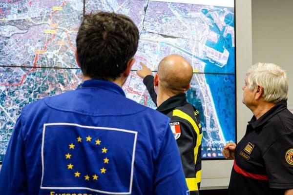 Two members of civil protection showcasing in an interactive map the consequences of wildfires.