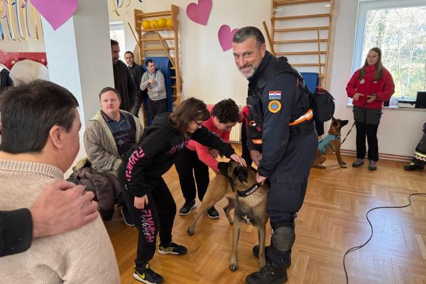 A first responder and his dog showcase their capabilities to several people with disabilities.