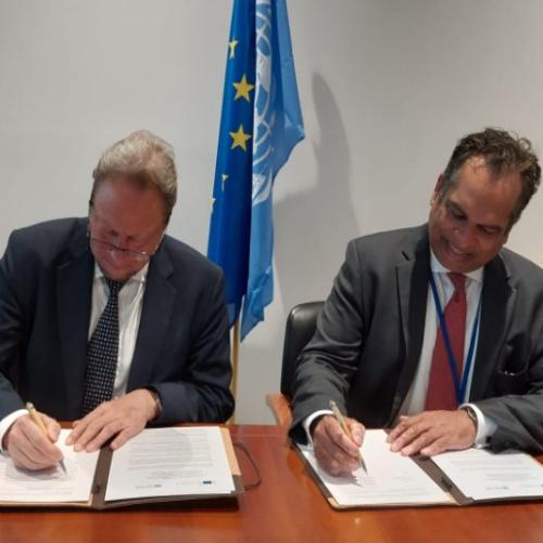Photo shows Michael Koehler, Acting Director-General of the European Commission’s department for European Civil Protection and Humanitarian Aid Operations, and Ramesh Rajasingham, UN Director, Coordination Division, UN-OCHA. They are signing the updated administrative arrangement with the EU and UN flags displayed behind them.