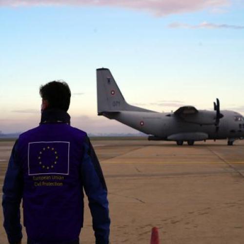 Man wearing EU vest in front of plane