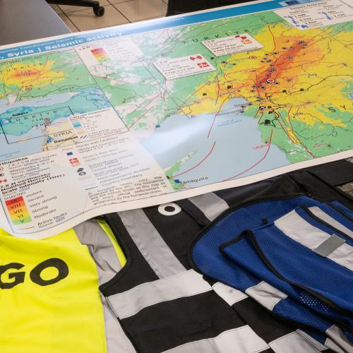 Map of earthquake and safety vests lying on a table