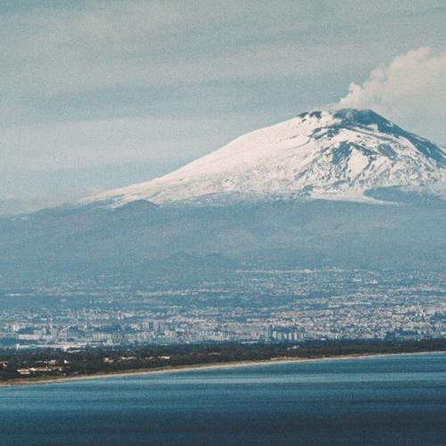  	       Credits-free picture, representing Mount Etna overlooking Catania, in a panoramic setting where mountain and sea come together