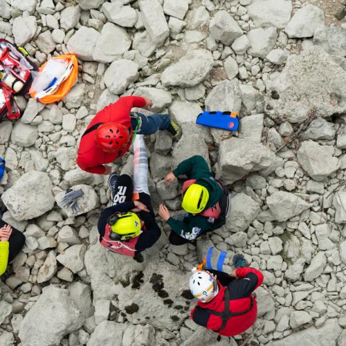 First responders taking care of a patient on rubble, during an exercise as seen from above.