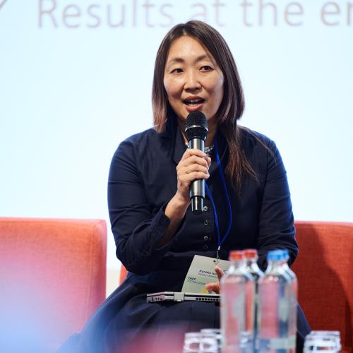 Professor Kanako Iuchi during the TAFF conference, seated with a microphone, talking during a panel.