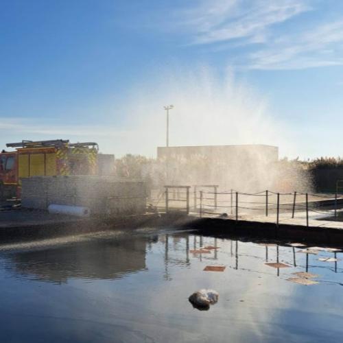 A pond full of water and a firefighter truck.