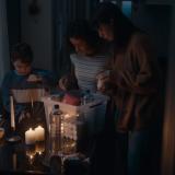 a family gathered together in a candle lit room with an emergency kit