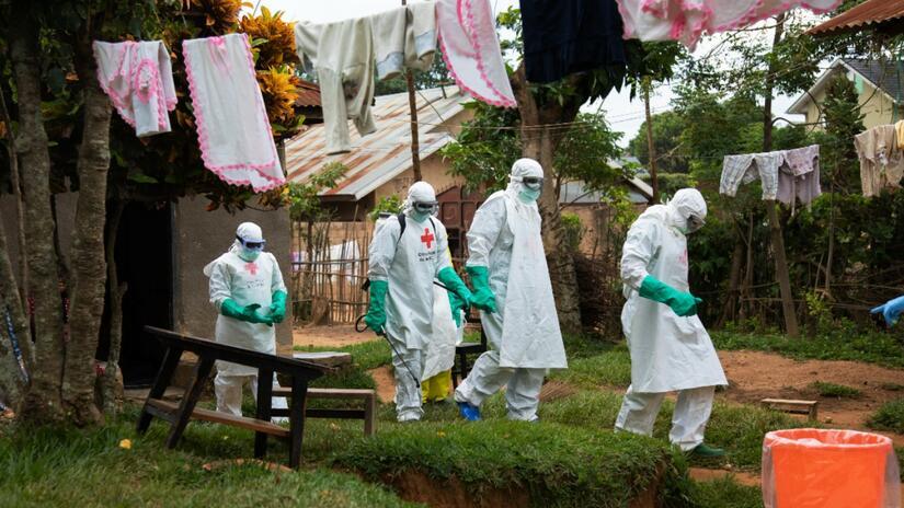 An IFRC safe and dignified burial team respond to an alert from family members who have lost a loved one suspected of Ebola. Photo: IFRC/Maria Santto