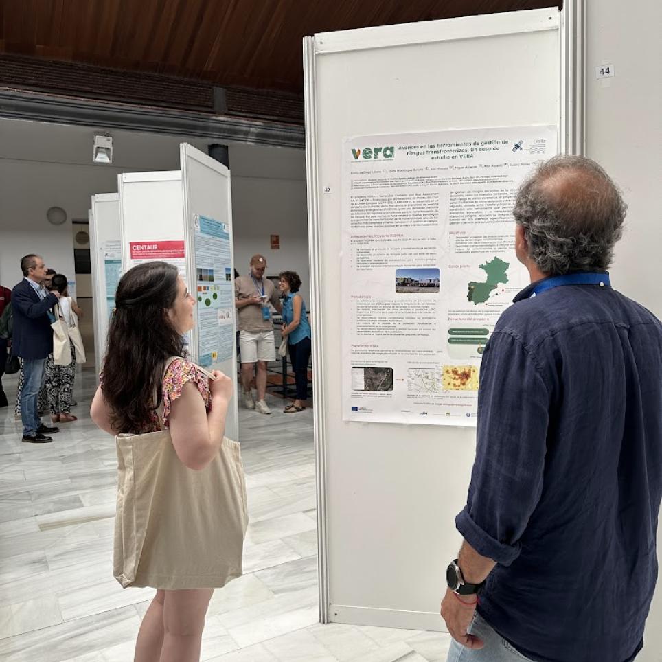 A photo of the poster with two attendants looking a it 