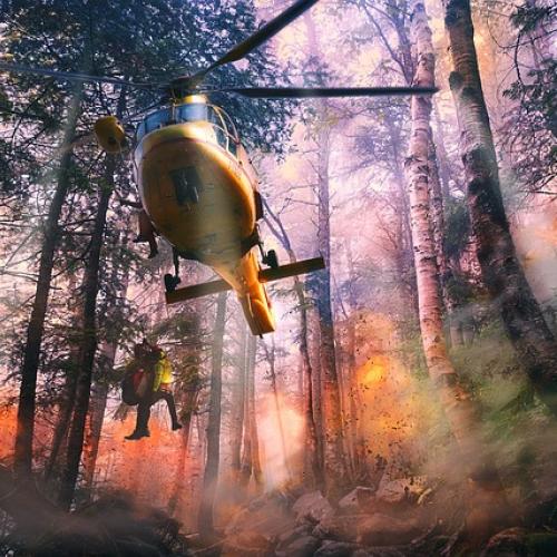 Emergency helicopter in a burning forest