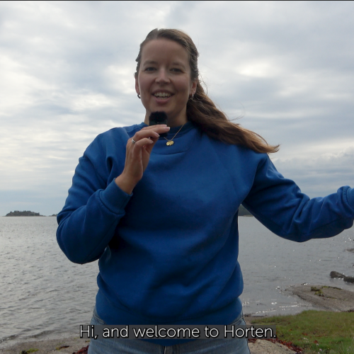 Women talking in a microphone in front of the ocean. 