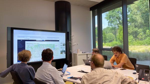 A group of people looking at a screen with the AHEAD Information System