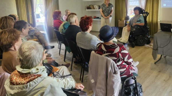 People in a room with a speaker in a wheelchair